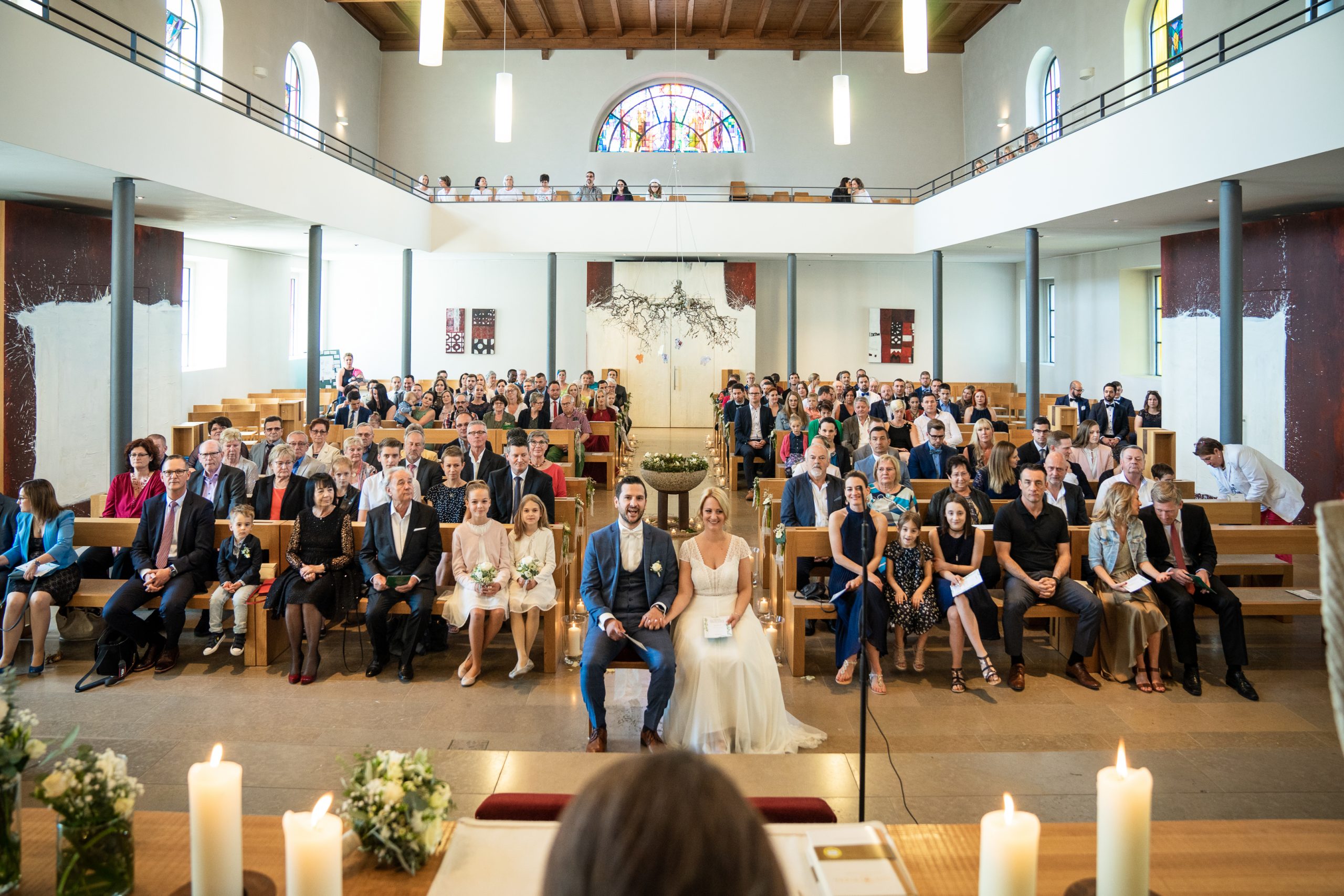 Hochzeitsgesellschaft in der Kirche mit Brautpaar in der Mitte
